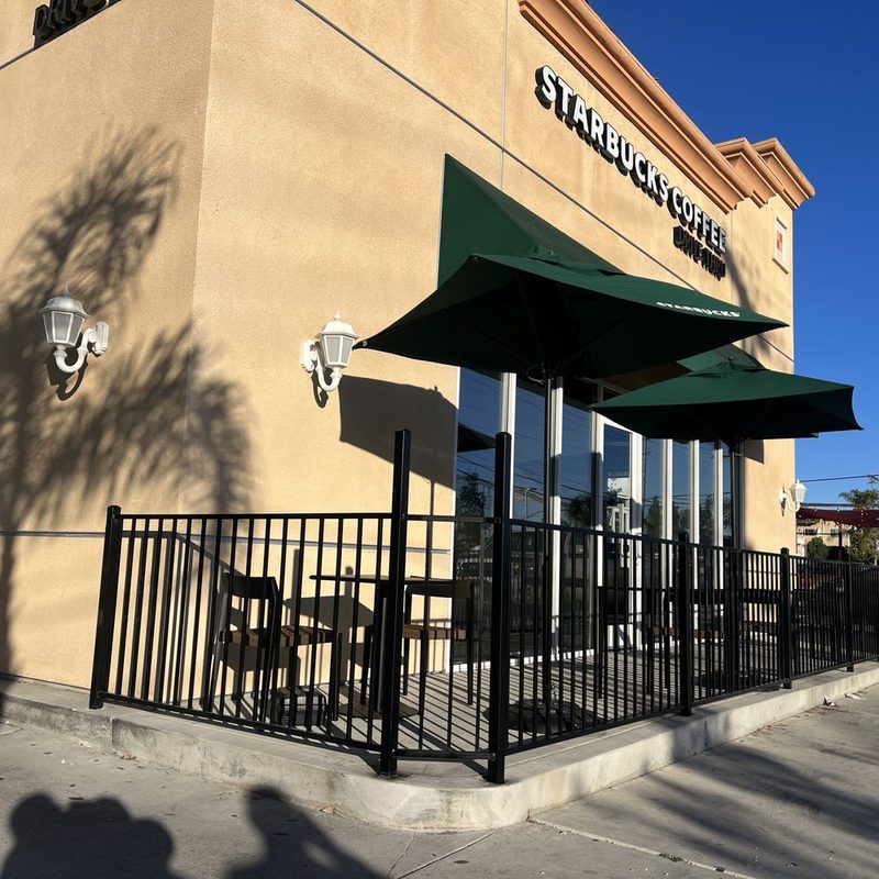 Black iron railing enclosing a commercial cafe patio