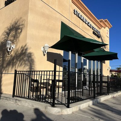 Black iron railing enclosing a commercial cafe patio