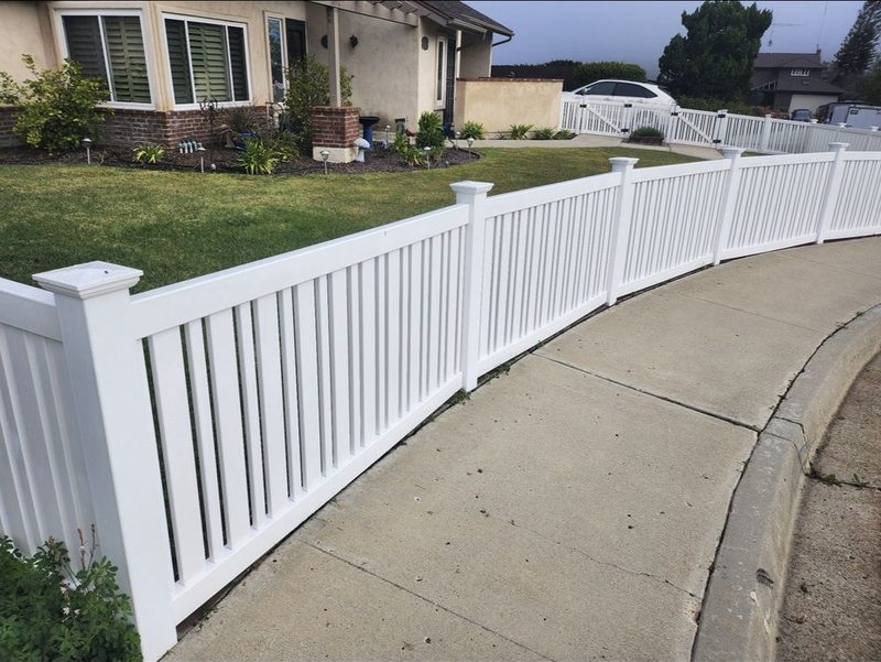 White vinyl picket fence following a curved front walkway