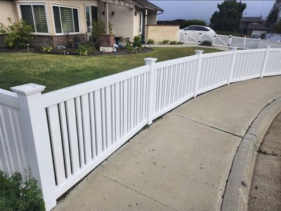 White vinyl picket fence following a curved front walkway
