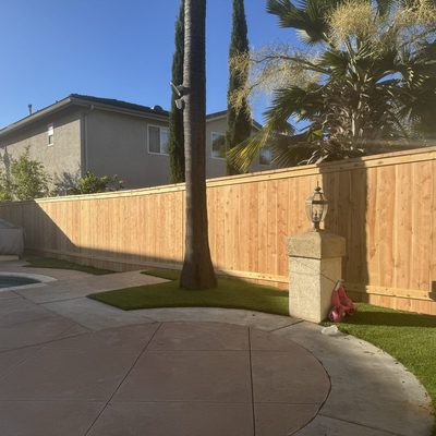 White vinyl fence with open picket top section beside a driveway