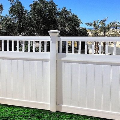 White vinyl fence with decorative open top panel enclosing a green lawn