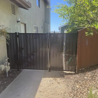 Stained wood fence and gate closing off a side yard